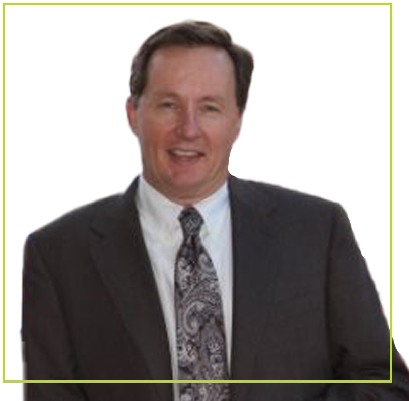 A separate company portrait of Patrick Cox wearing a dark suit and patterned tie