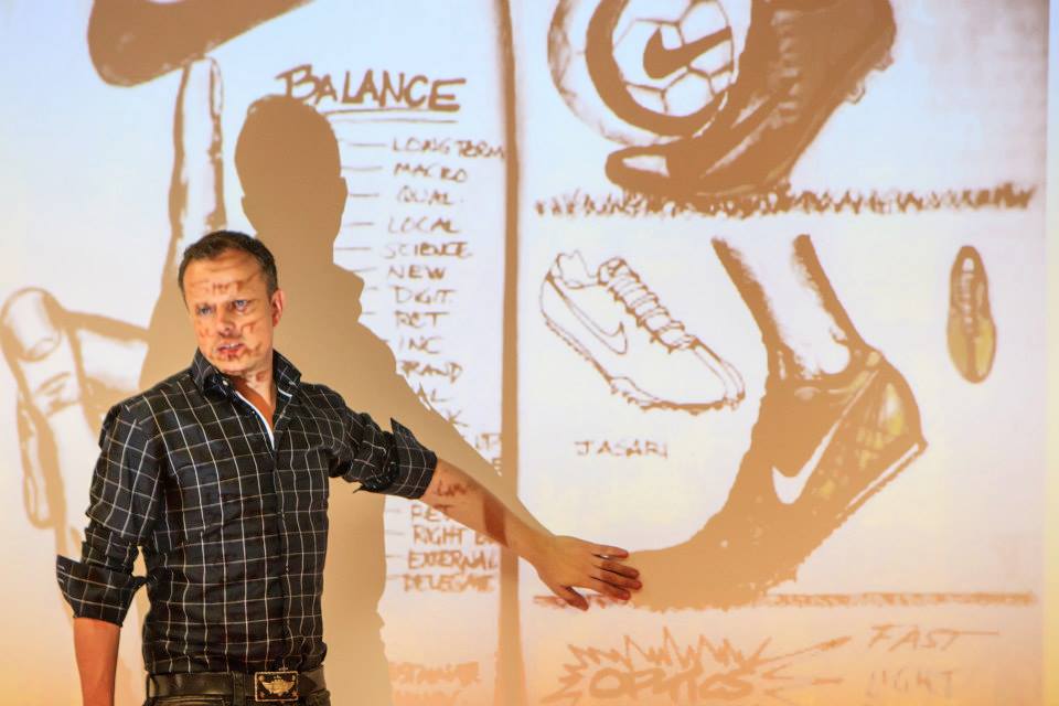 Patrick van der Pijl presenting in front of a projected illustration of shoes and a business model