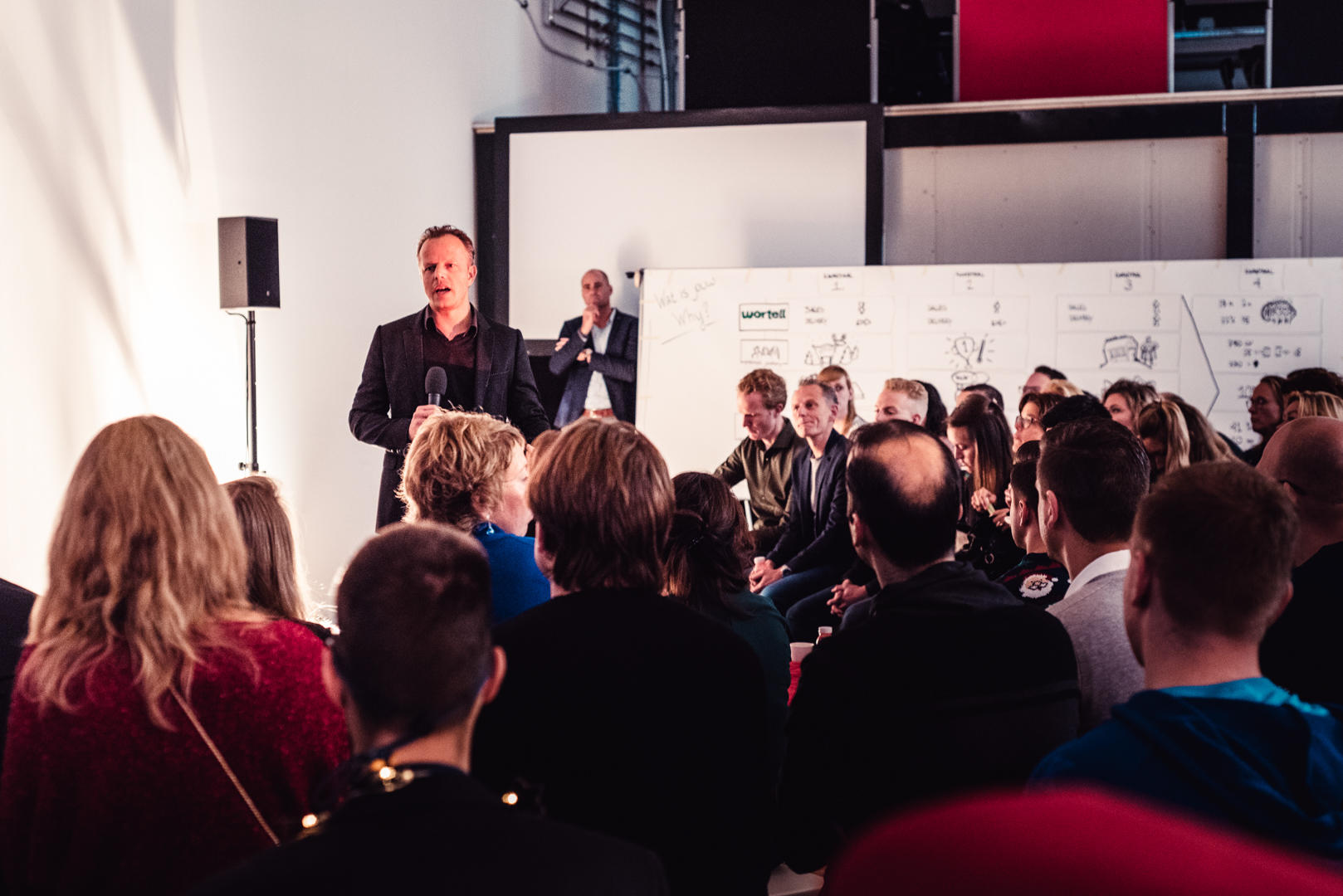 Patrick van der Pijl speaking to workshop participants beside a board covered in drawings