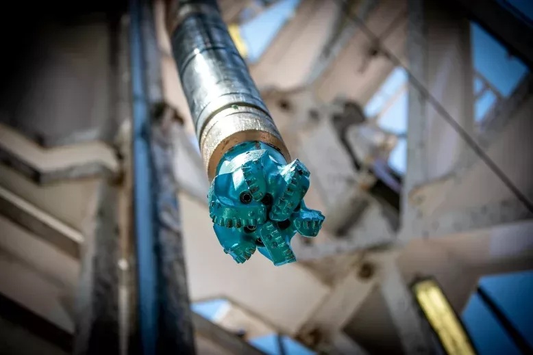 Close view of an Ulterra drill bit attached to drilling pipe