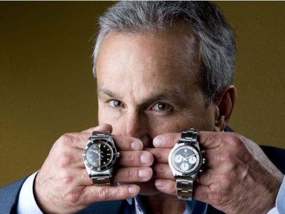 Paul Altieri holds a Rolex Submariner and Daytona beside his face