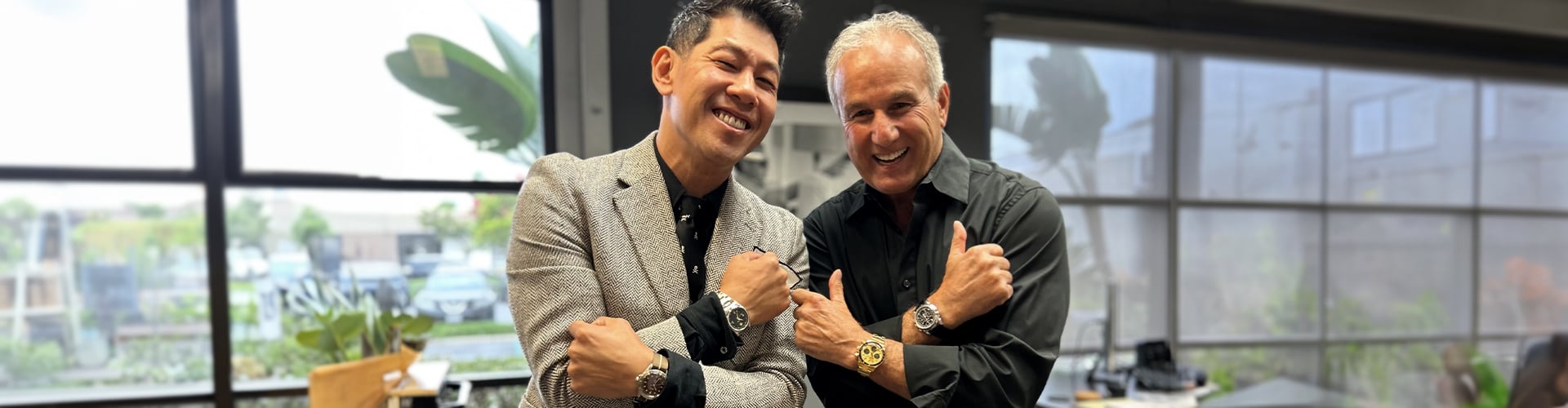 Morgan King, left, and Paul Altieri, right, smile while displaying watches on their wrists