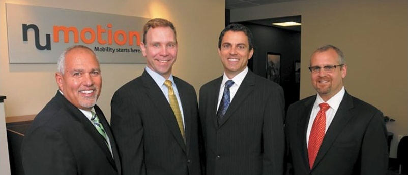 Numotion executives Frank Biondello, Dan Prestegaard, Paul Bergantino, and David Hess standing together in 2014