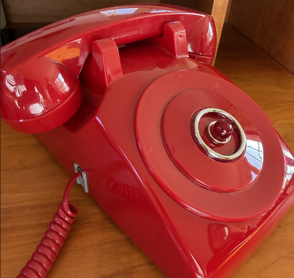 Kayak’s red desk telephone with a coiled cord