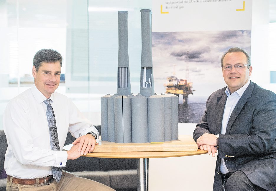 Duncan Manning on the left and Paul Goodfellow on the right, seated beside a model of a Brent offshore platform