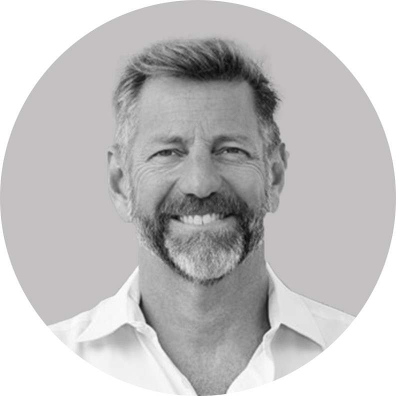 An archival black-and-white photograph of Paul Grayson, smiling