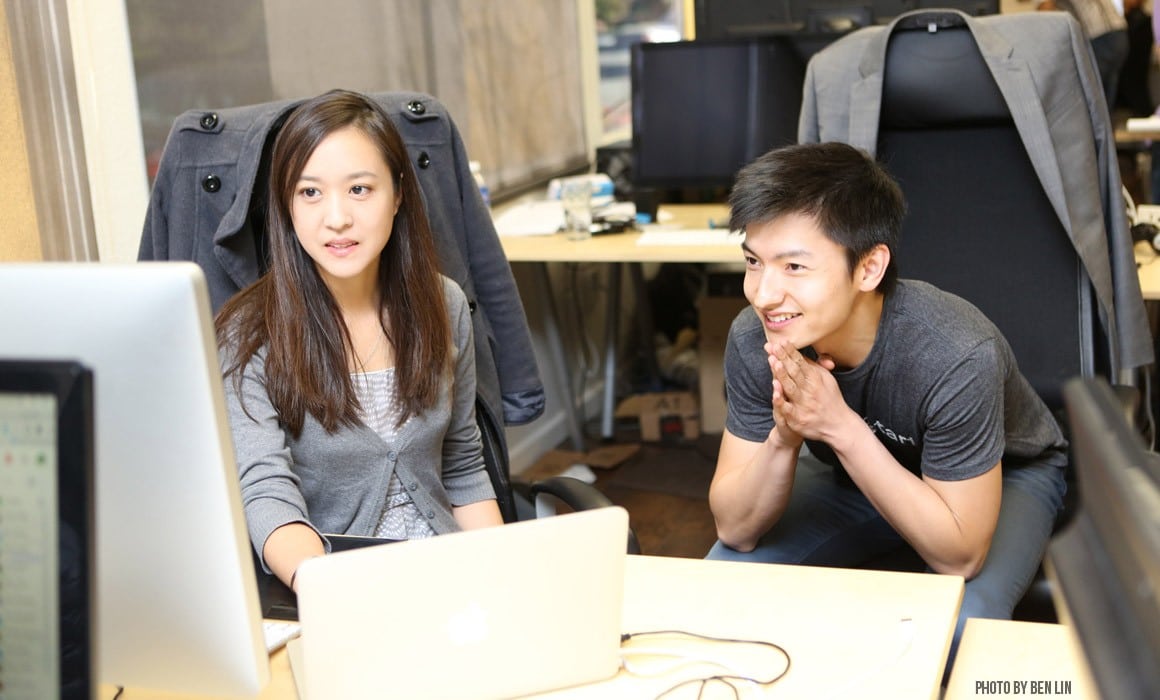 Paul Gu leans toward a computer screen beside a colleague in Upstart’s office.