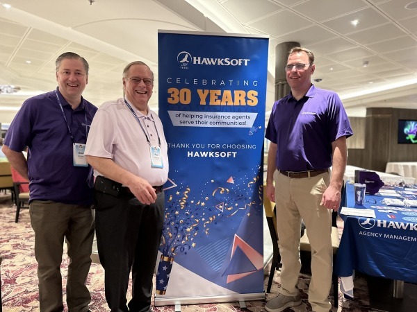 Jason Hansen, Paul Hawkins and Sean Hawkins beside HawkSoft’s thirtieth anniversary sign
