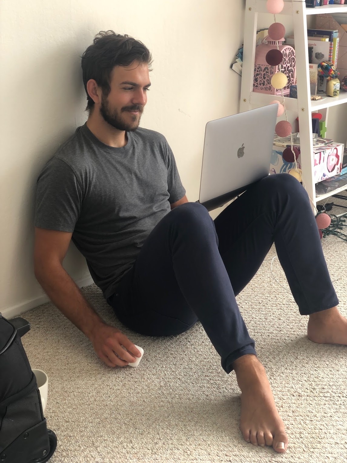 Paul Klein IV working on a laptop while seated against a wall during the Stream Club years