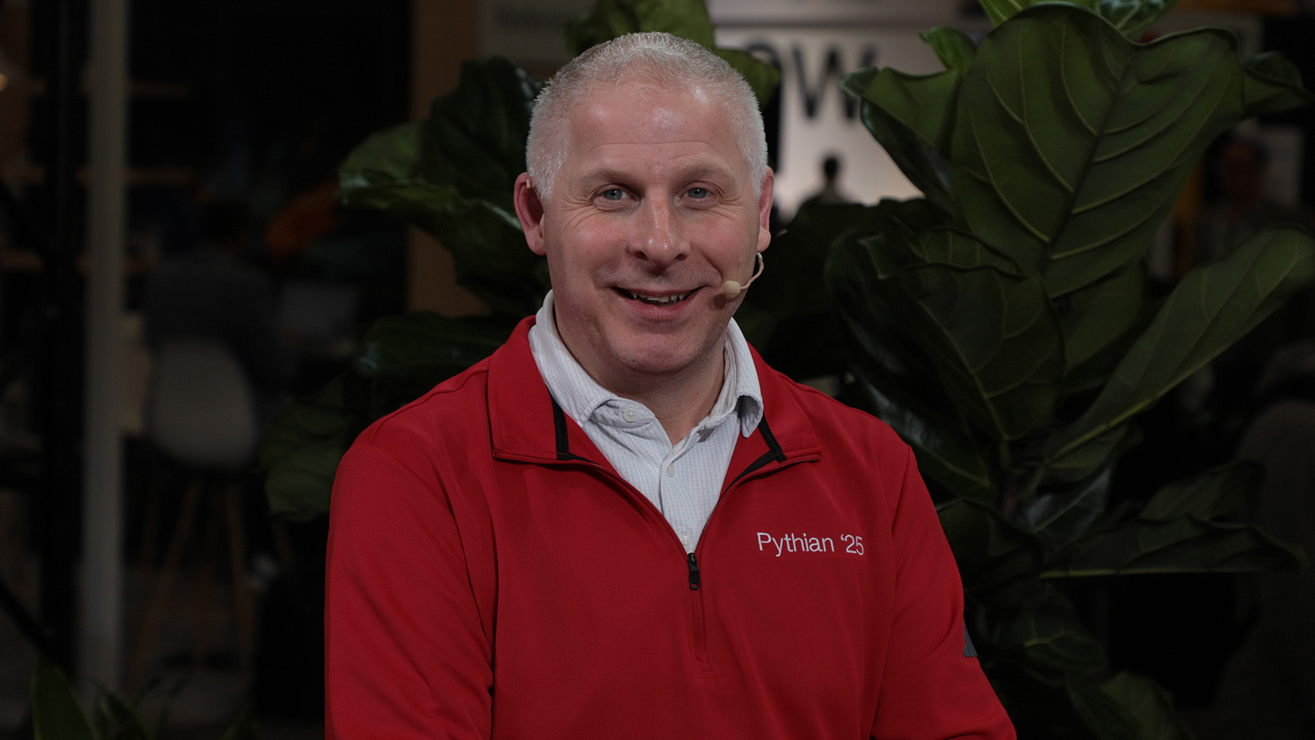 Paul Lewis speaking on camera in a red Pythian 2025 jacket