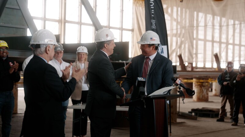 Paul Lwin, right, shaking hands with Senesco Marine president Ted Williams at a shipyard partnership announcement