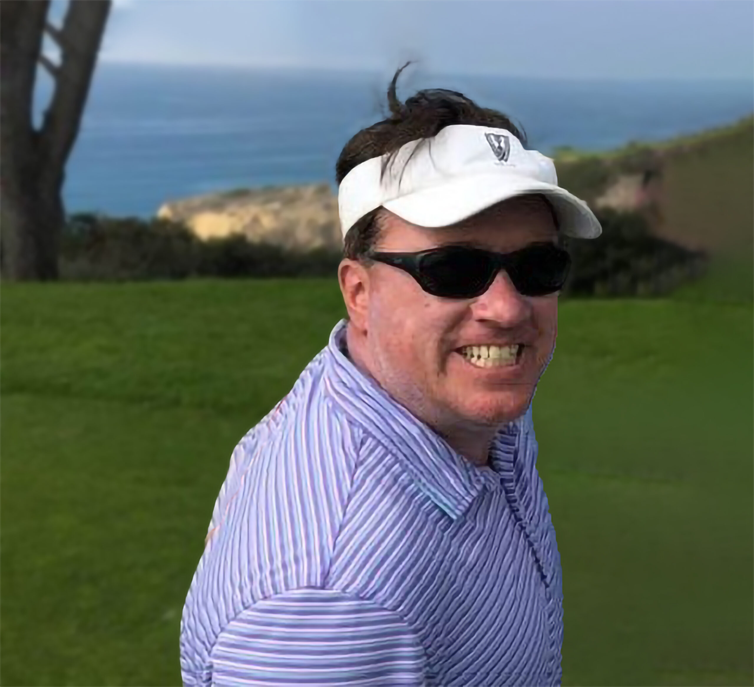 Paul M. Wilson smiling outdoors on a golf course