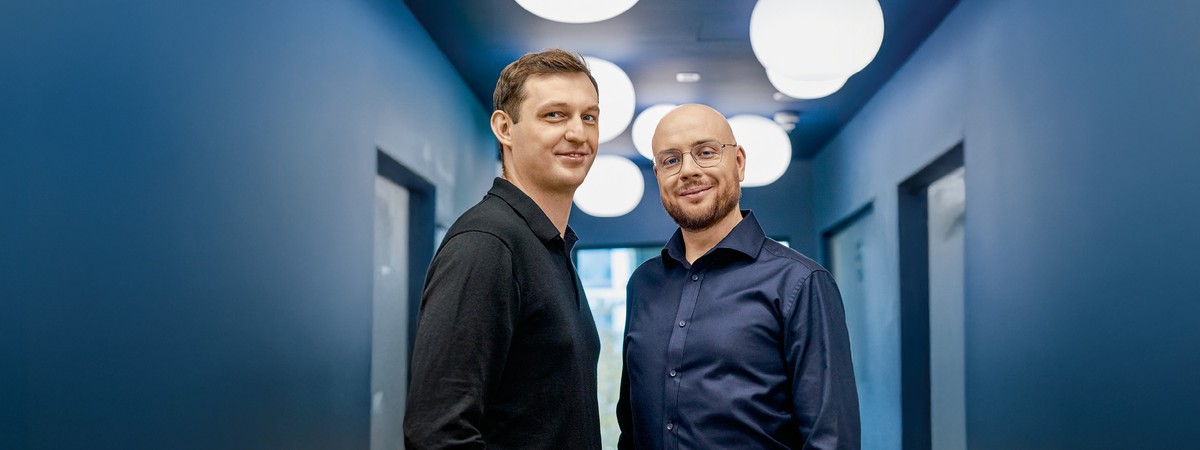 Pawel Hytry, left, and Spacelift co-founder Marcin Wyszynski standing together in a blue corridor