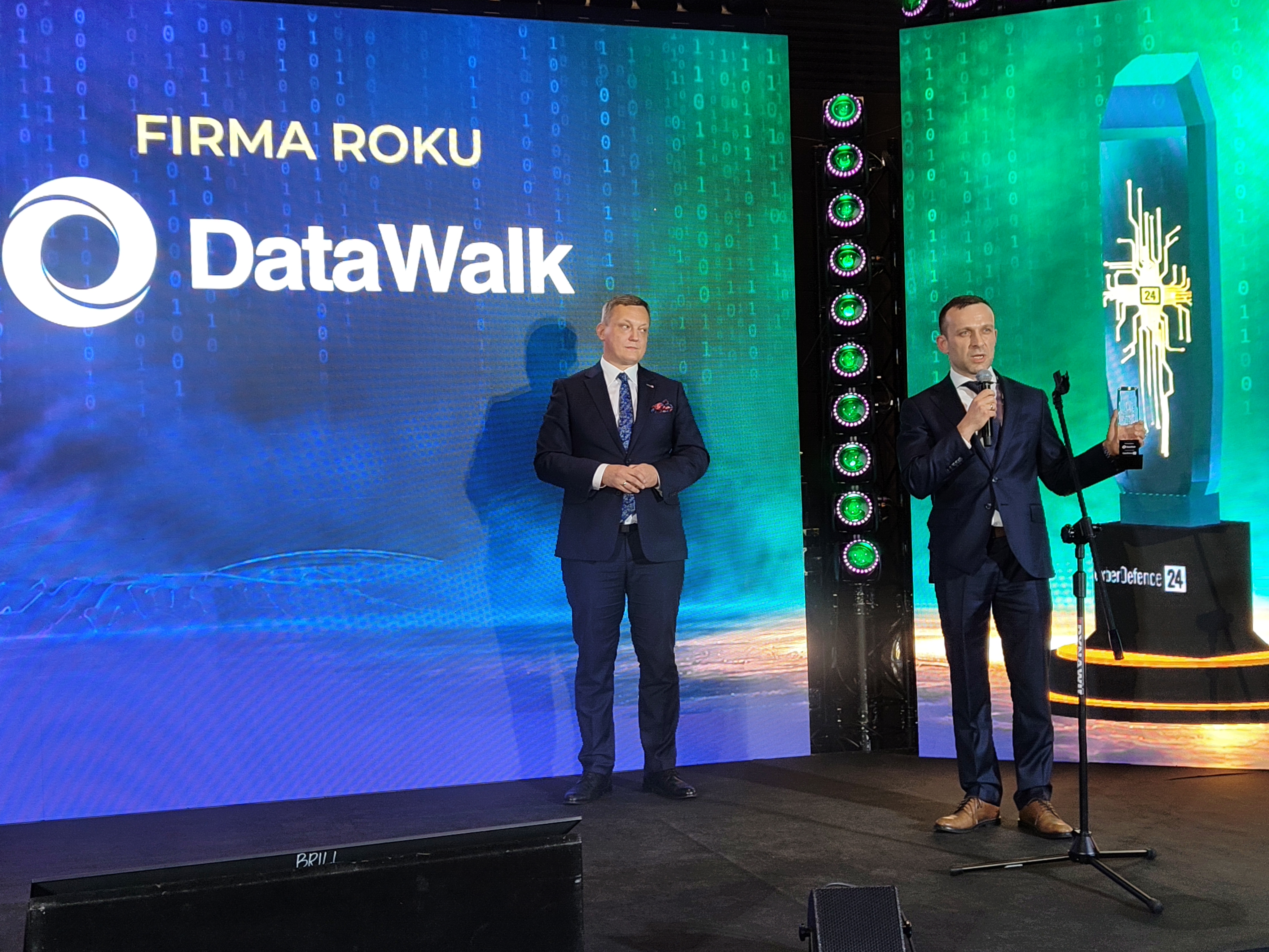 Paweł Wieczyński holding DataWalk’s award onstage beside Krzysztof Gawkowski