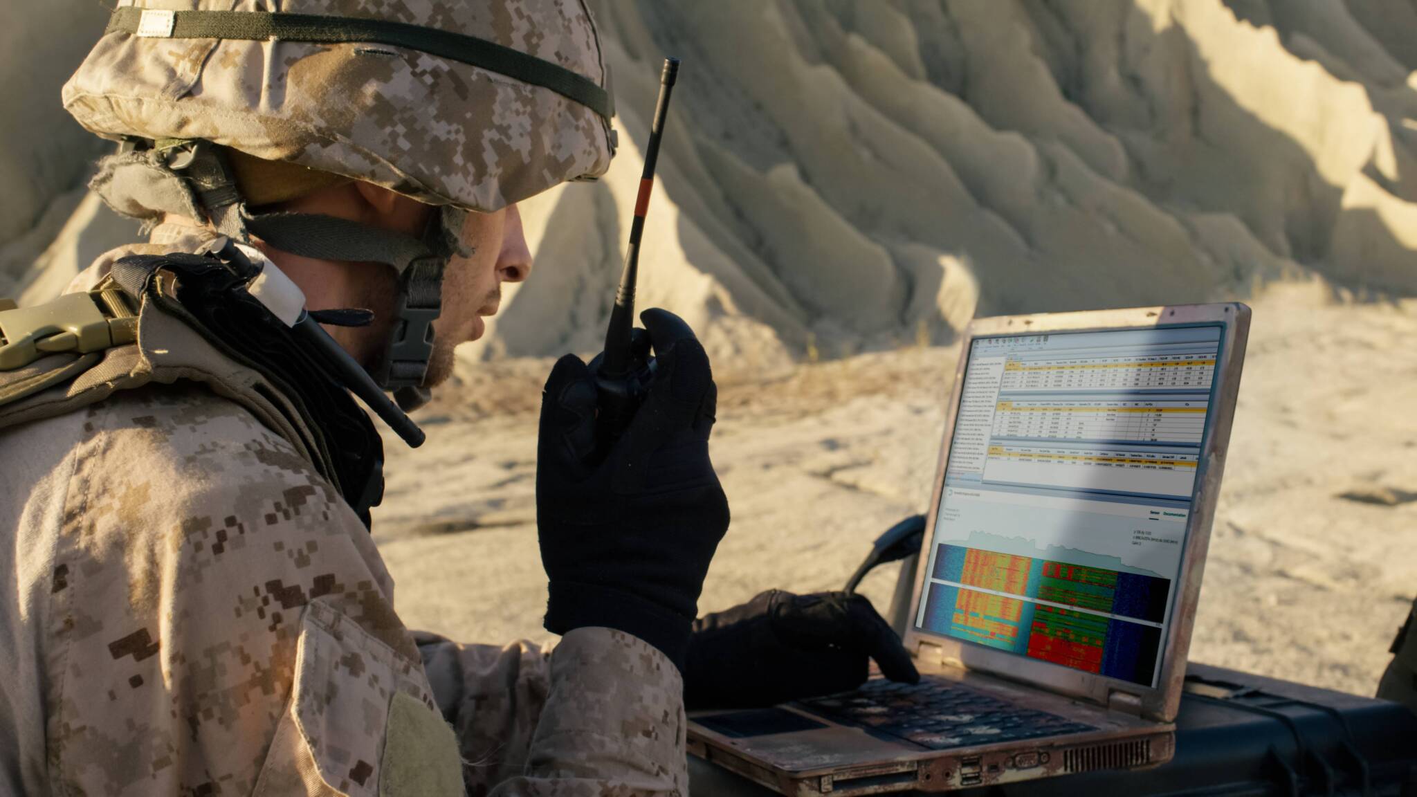 PCTEL promotional field image of a person with a radio examining spectrum information on a rugged laptop