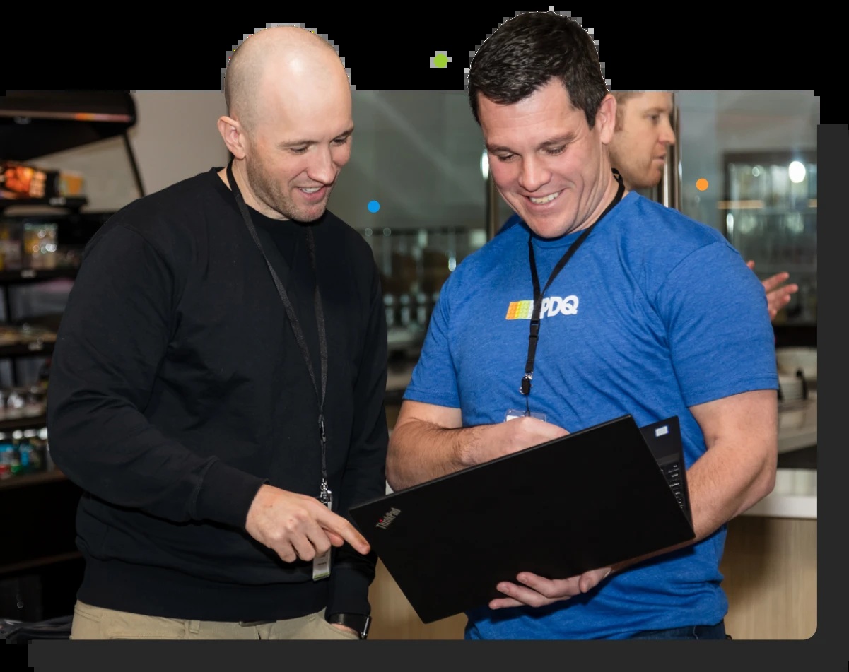 Two PDQ staff members examining a ThinkPad laptop