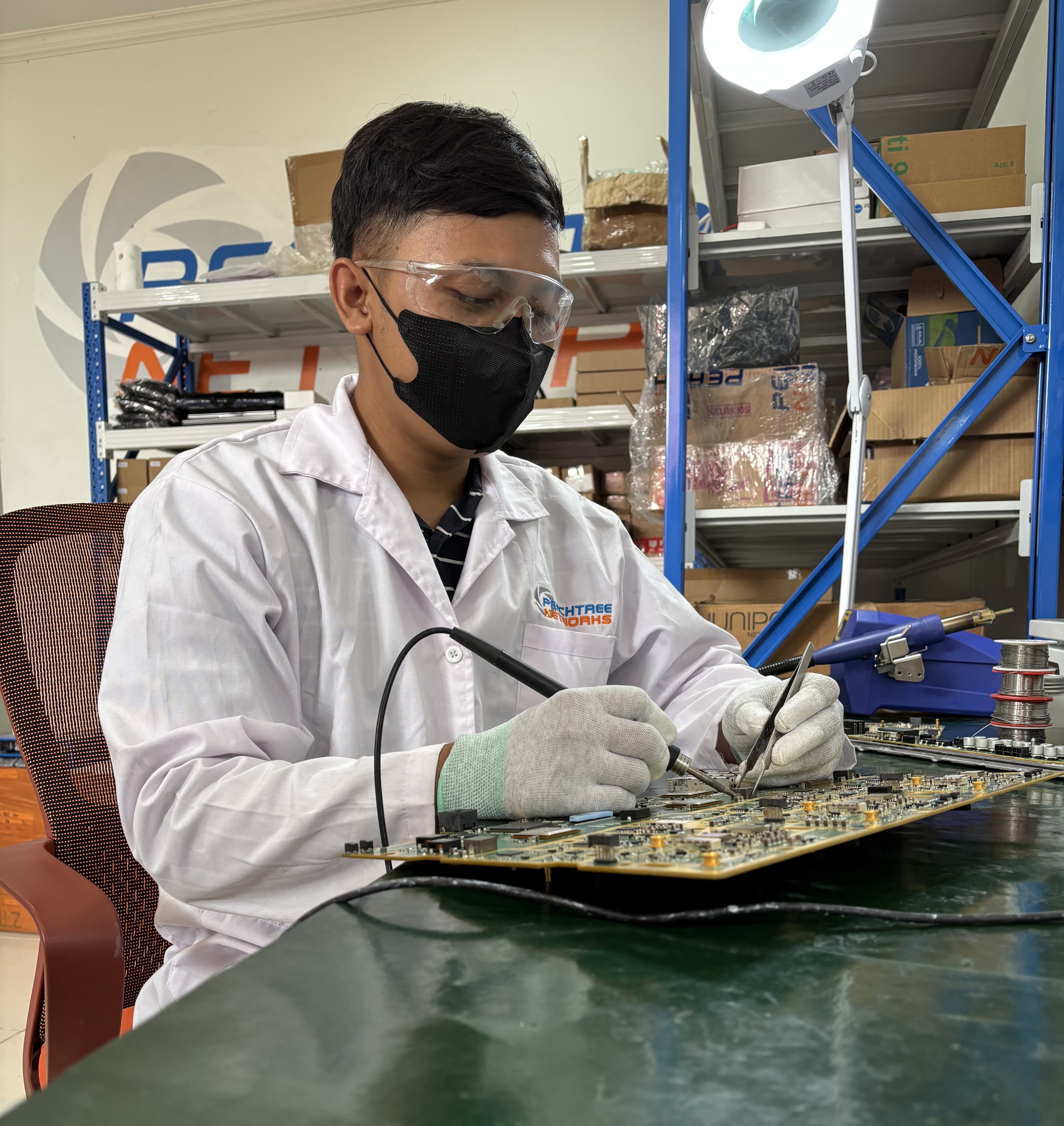 Peachtree Networks engineer working on an electronic circuit board