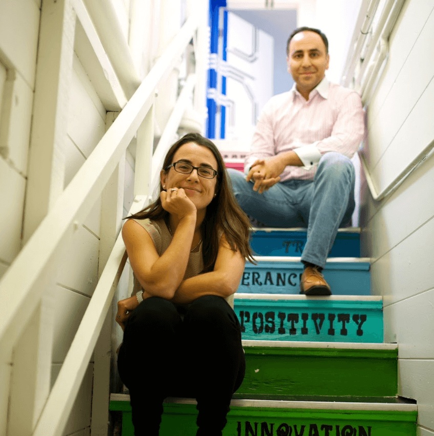Mar Hershenson and Pejman Nozad sitting on colorful office stairs