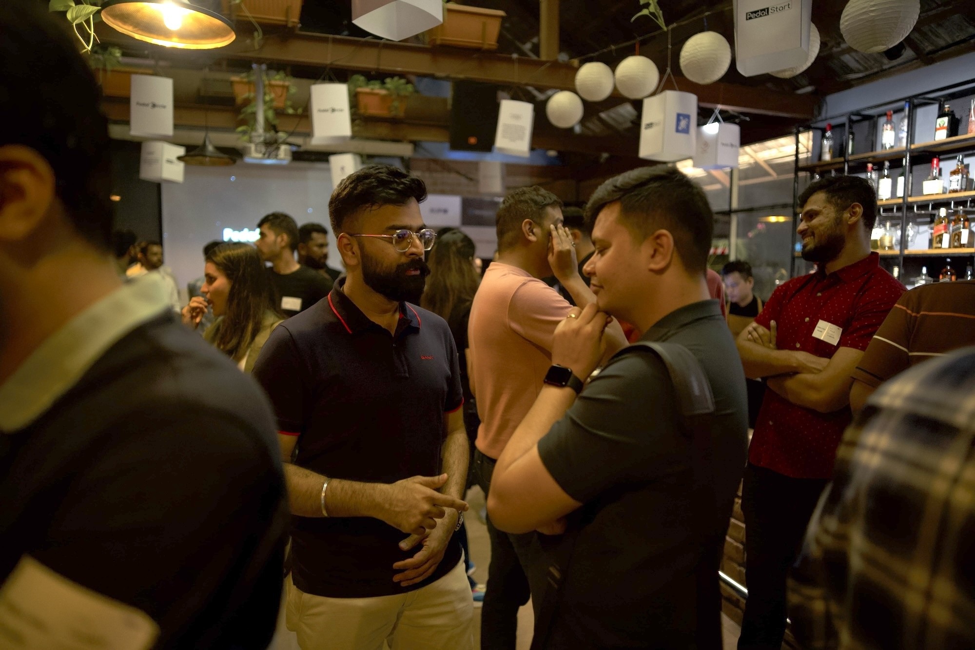People in conversation at a founder gathering shown in PedalStart’s gallery
