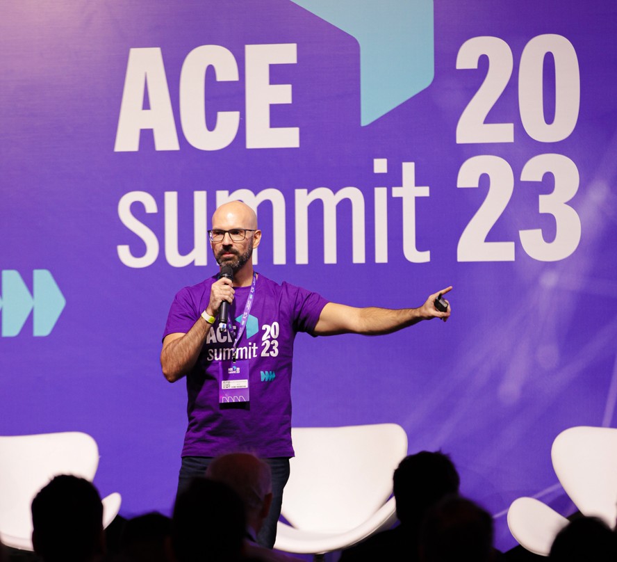 Pedro Waengertner speaking on the purple-lit ACE Summit 2023 stage