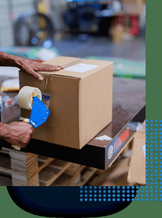 Pegasus warehouse team member taping a shipping box