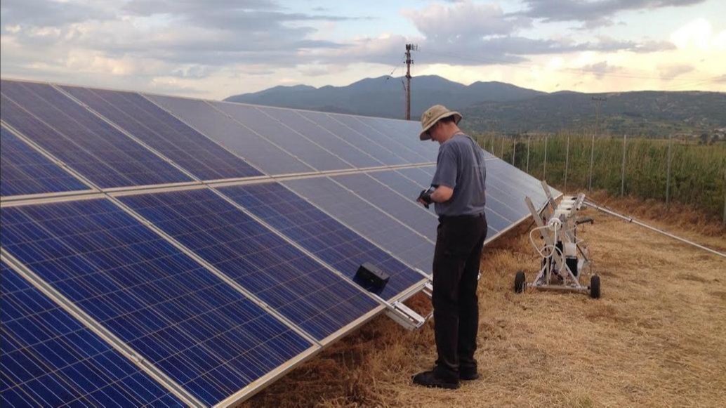 A worker beside solar panels and field application equipment in Pellucere’s published photograph