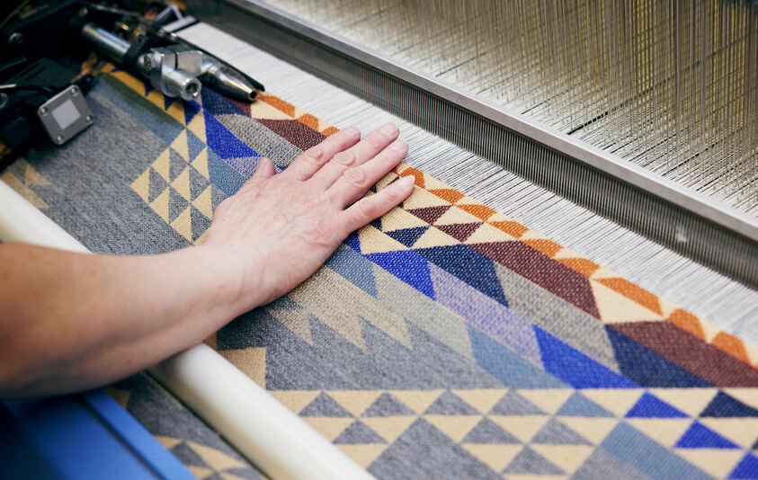 A Pendleton mill worker attending wool weaving machinery