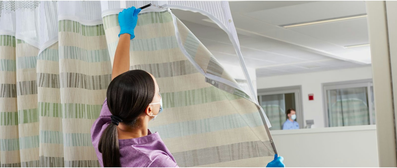 A hospital worker replacing a Cintas privacy curtain