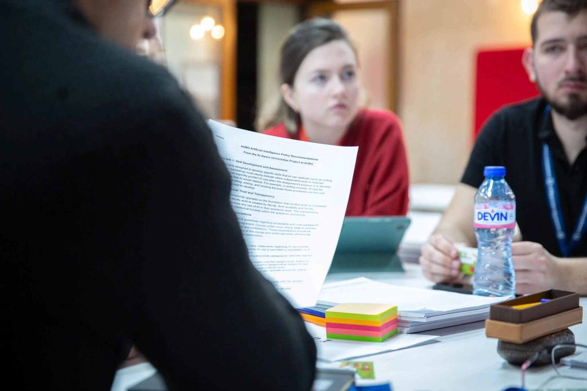 Participants discussing printed AI policy recommendations at the American University in Bulgaria