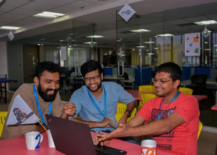 Three People10 colleagues collaborating around a laptop in the office