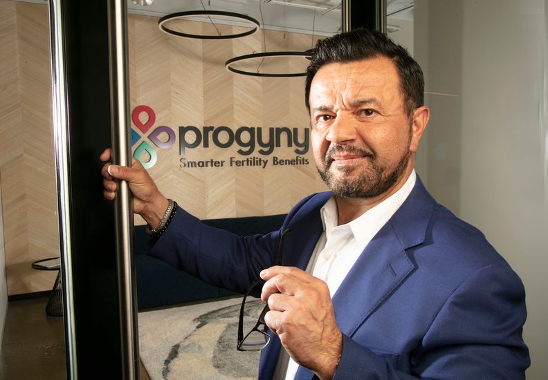 Pete Anevski holding a glass office door at Progyny’s Manhattan workspace
