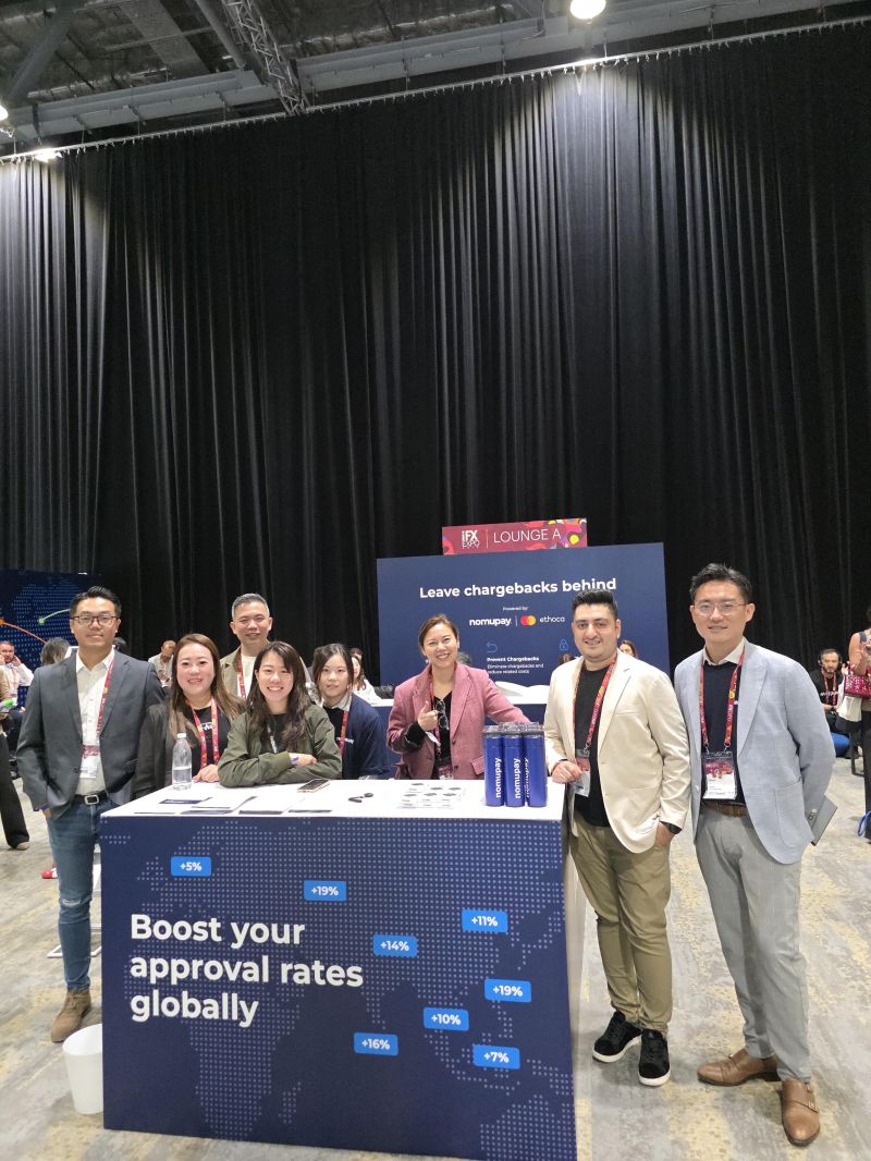 A group of NomuPay team members at a conference booth.