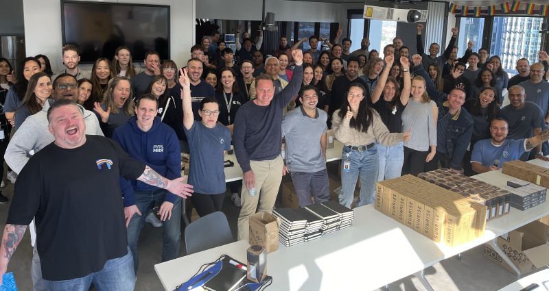 PayPal Australia employees gathered behind tables of boxes and supplies during Impact Day