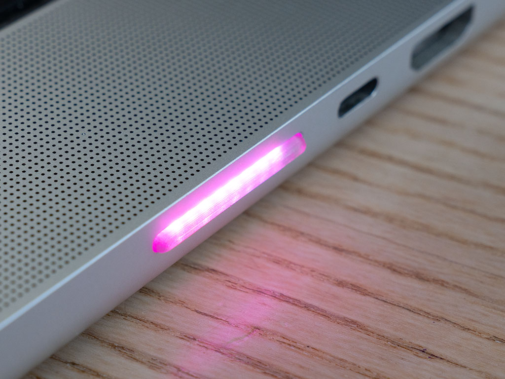 SidePulse Pro glowing pink from the SD card slot of a MacBook Pro