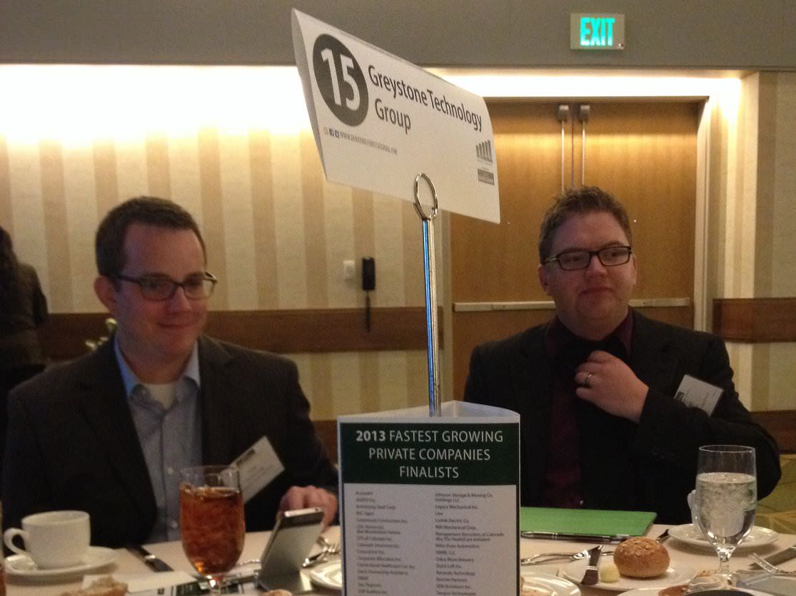 Jesse Armstrong, left, and Peter Melby, right, seated at the 2013 Denver Business Journal awards dinner