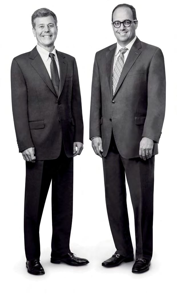 Stephen Richardson, left, and Peter Moglia, right, standing together in suits