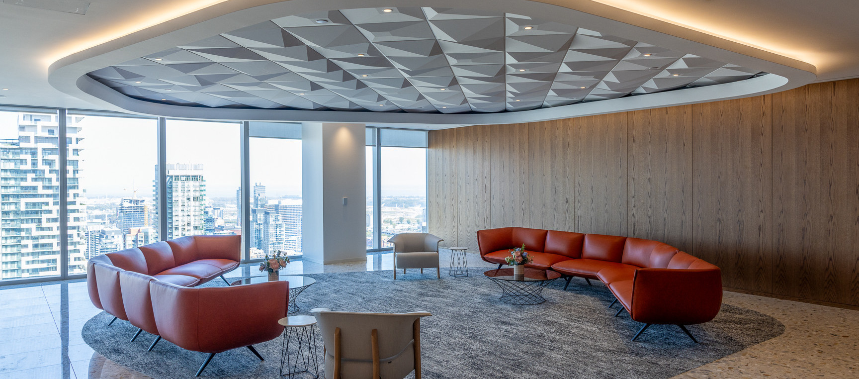 A light-filled lounge in Cassels' Toronto office with curved rust-coloured seating