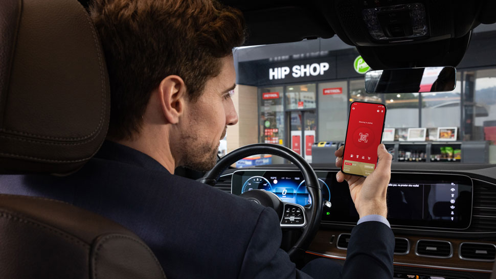 Driver using the Petrol mobile application in a car outside a Hip Shop