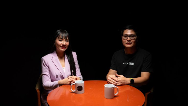 Host Tu An and Pham Chi Nhu seated across an orange table during a Vietnam Innovators conversation