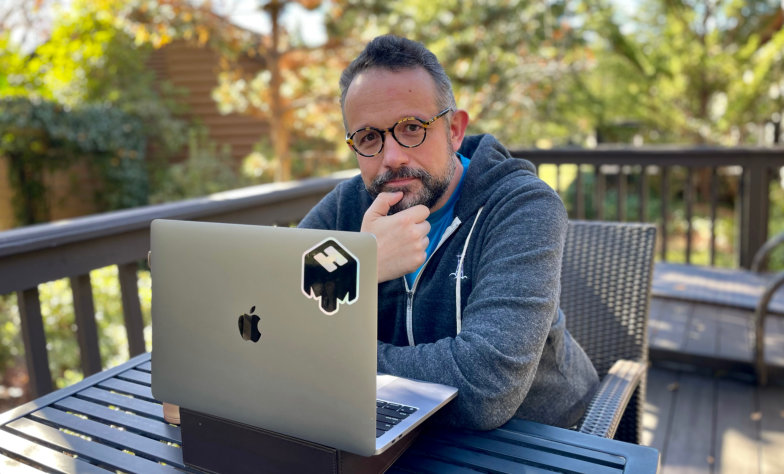 Phil Libin seated outdoors at a table with an open laptop