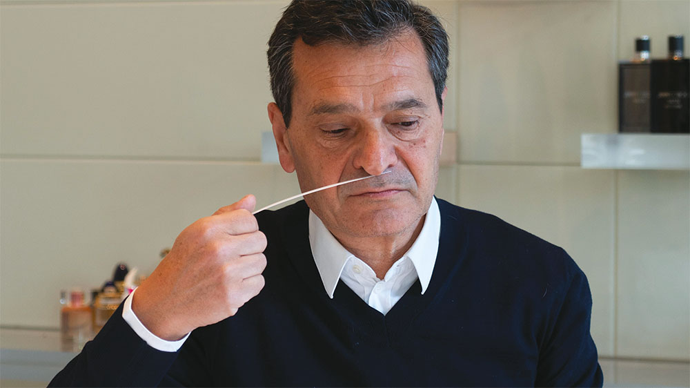 Philippe Benacin evaluates a fragrance using a paper blotter