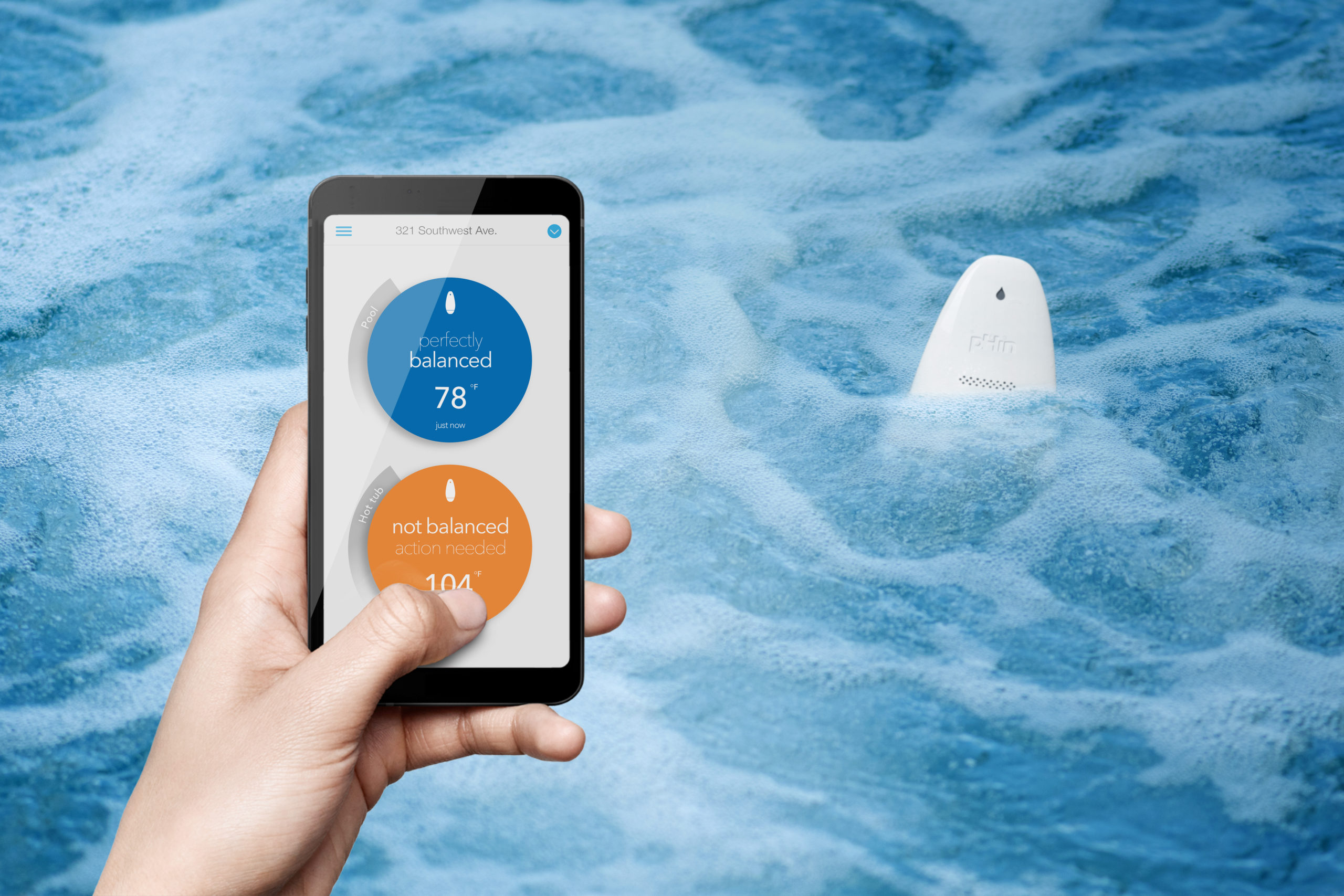 A pHin monitor floating in bubbling spa water beside a phone displaying pool and hot-tub status