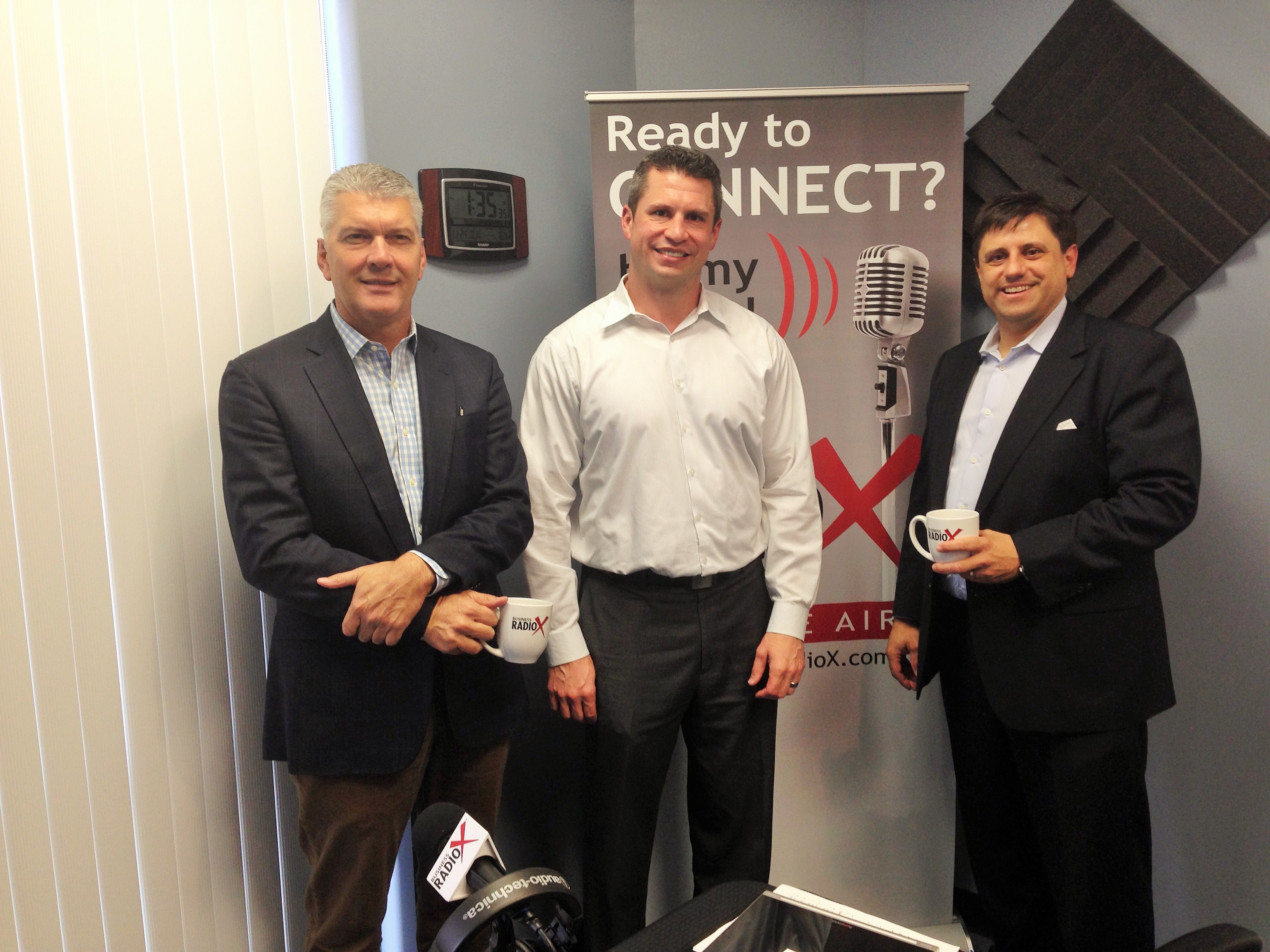 Pierre Naudé, at left, standing with fellow participants in a Business RadioX studio