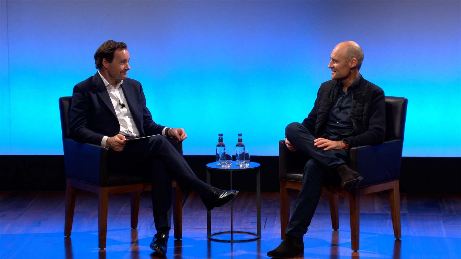 Clif Marriott interviews Pieter van der Does, seated at right, on a blue-lit stage in London
