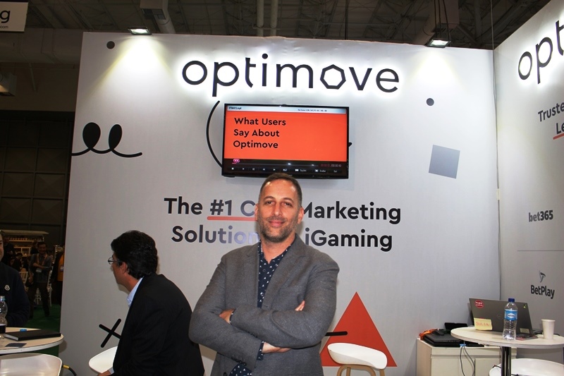 Pini Yakuel standing with folded arms at Optimove’s exhibition stand