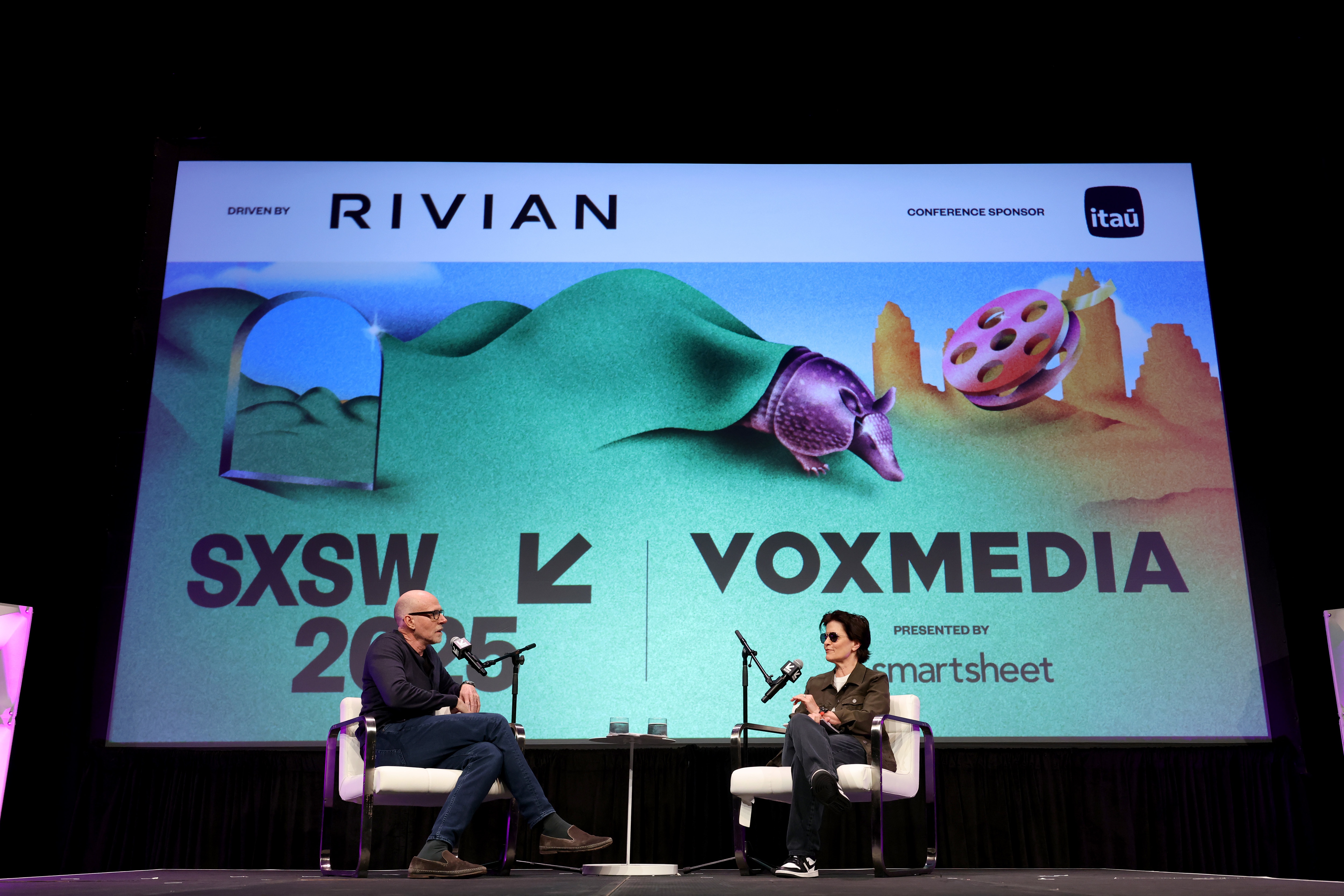 Scott Galloway and Kara Swisher seated onstage at the Vox Media podcast stage during SXSW 2025