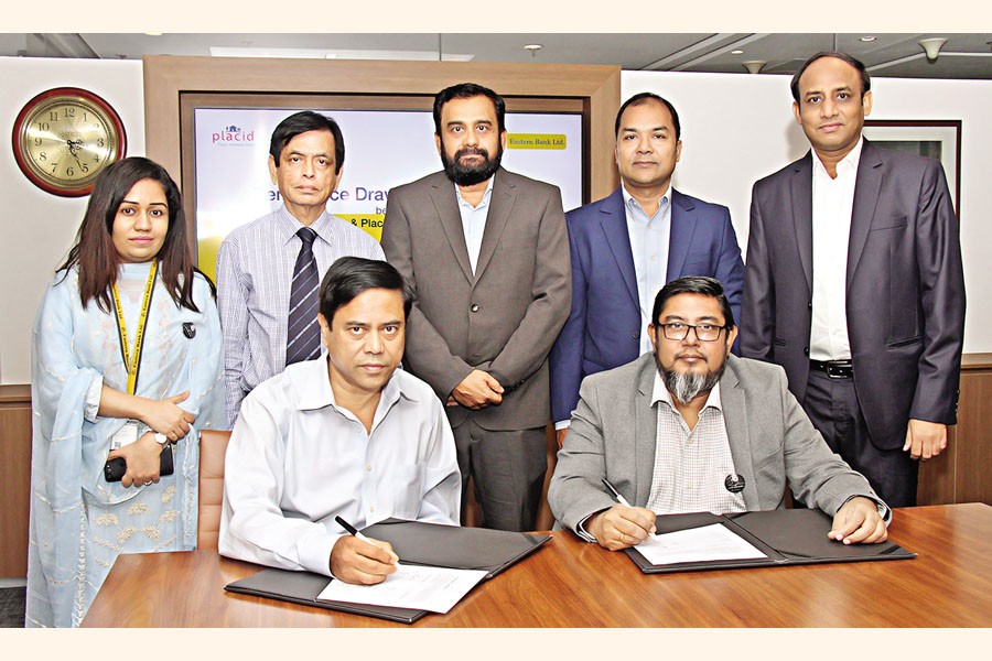Eastern Bank and Placid Express representatives gathered around a table at a remittance agreement signing