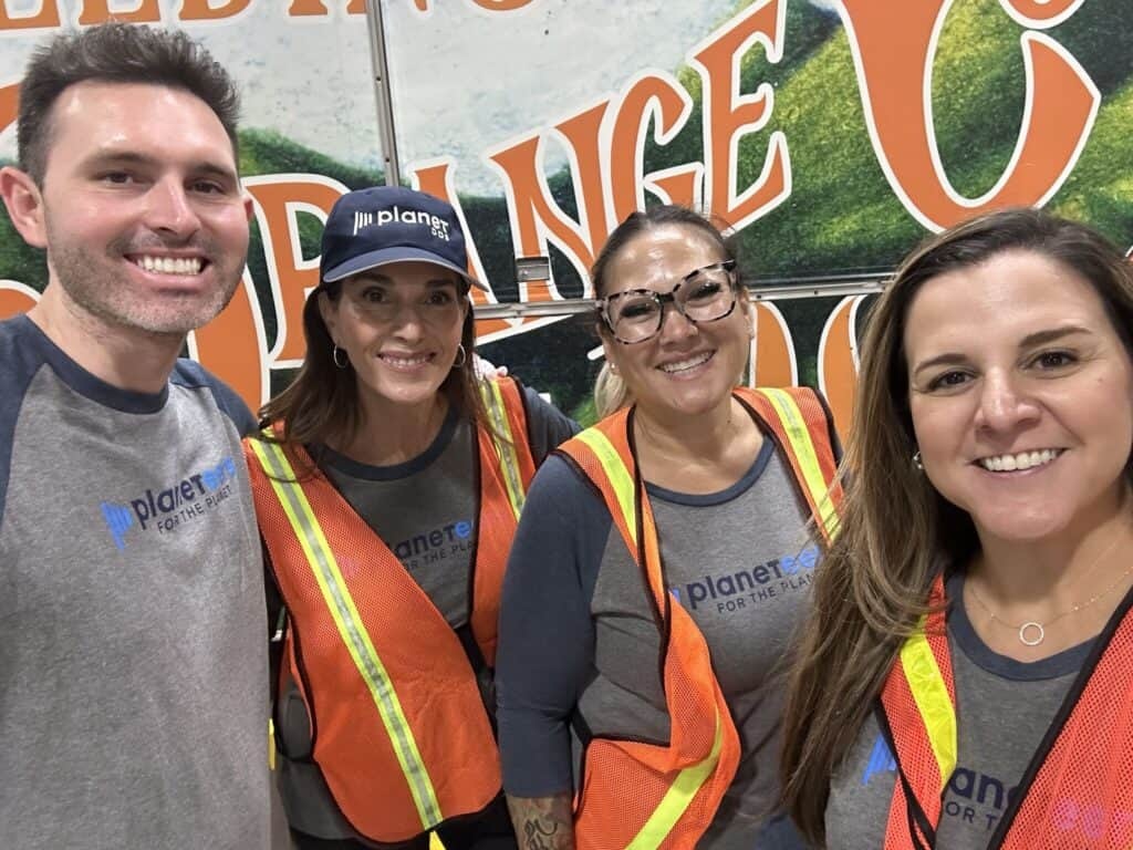 Planet DDS team members in volunteer shirts and orange safety vests