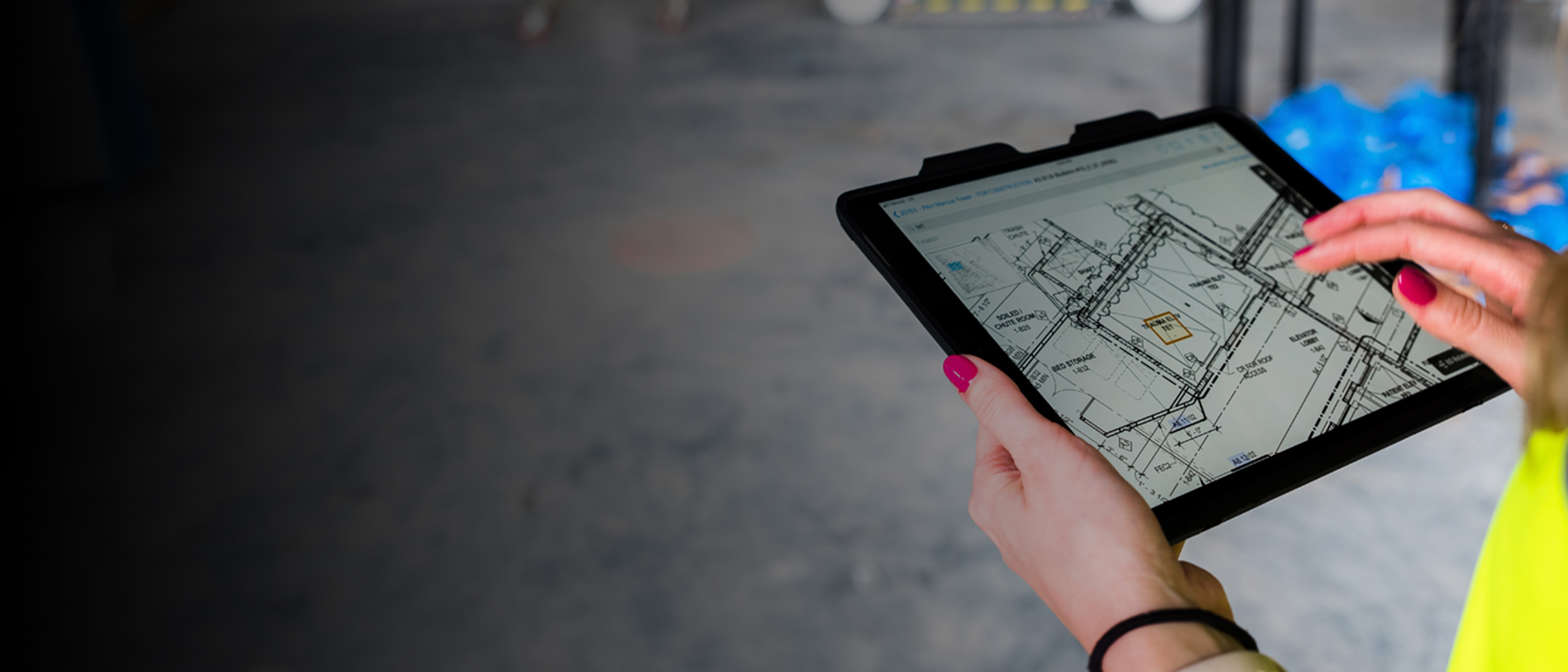 Construction professionals consulting a tablet at a jobsite