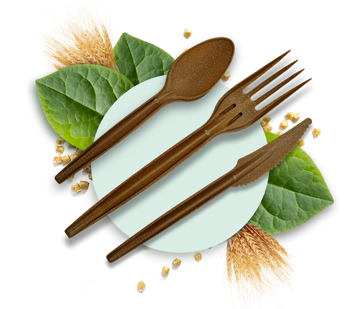 PlantSwitch compostable fork, spoon and knife arranged on a plate with leaves and wheat